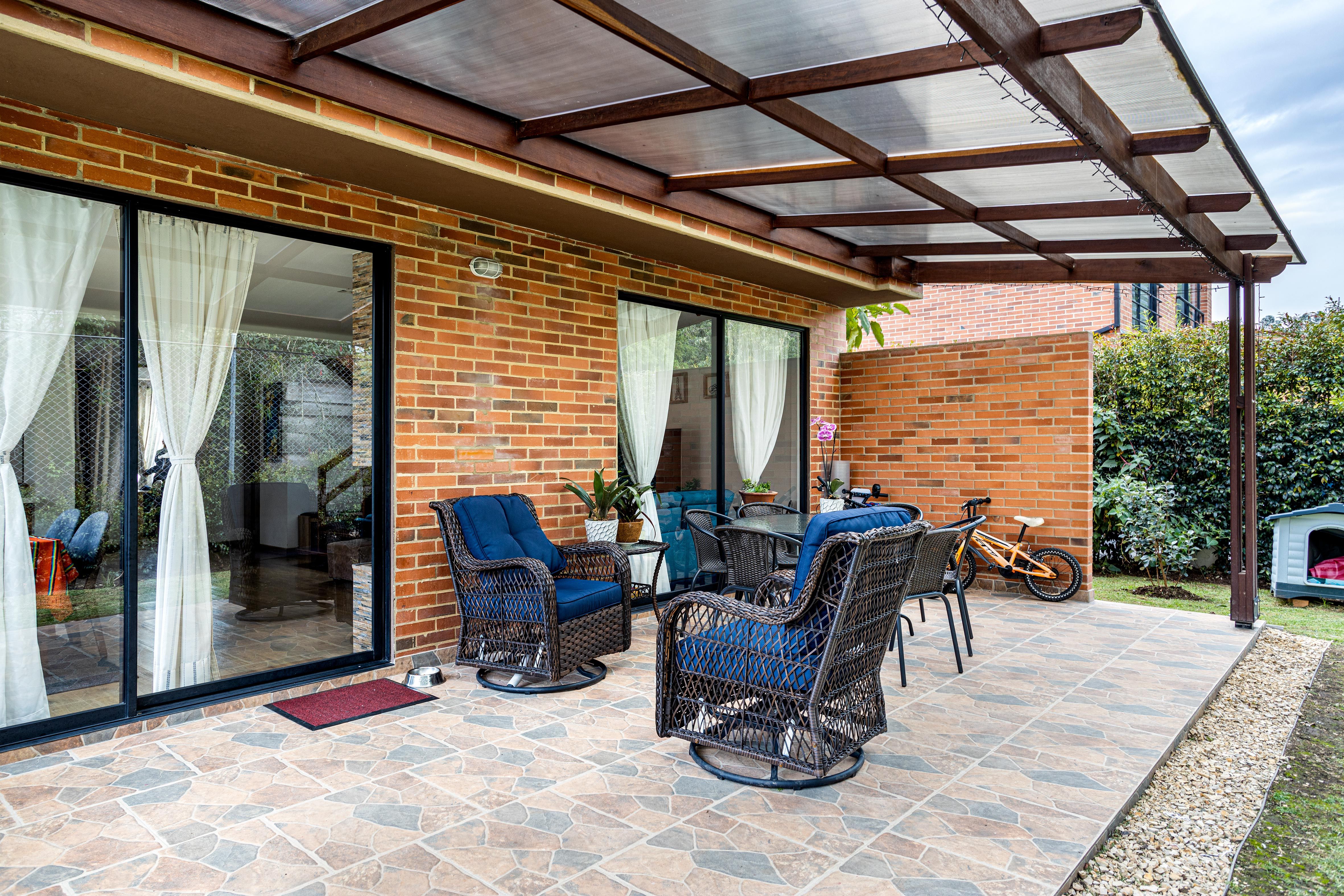 Inviting brick patio with wicker chairs and potted plants