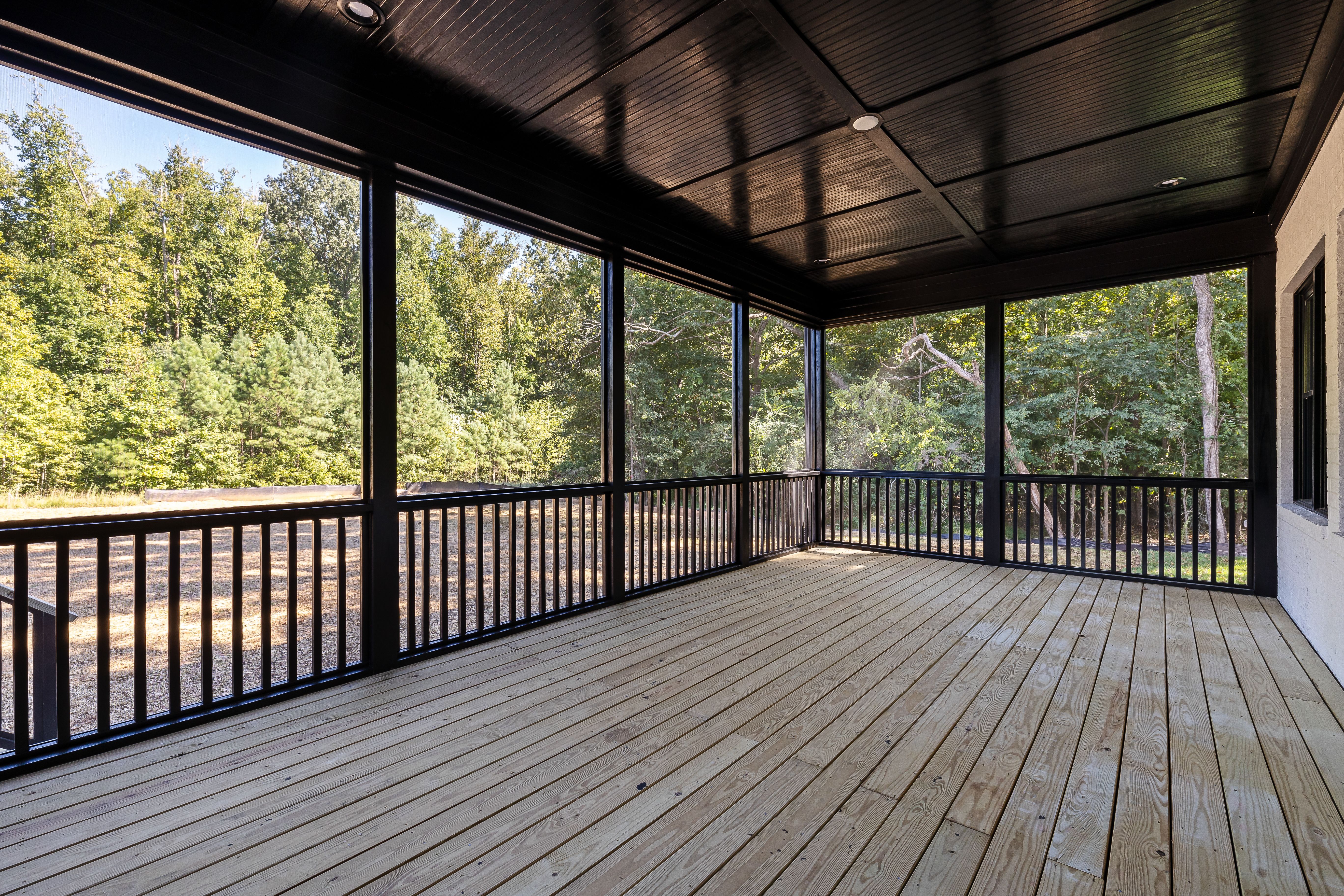 Large wooden patio overlooking a lush green forest