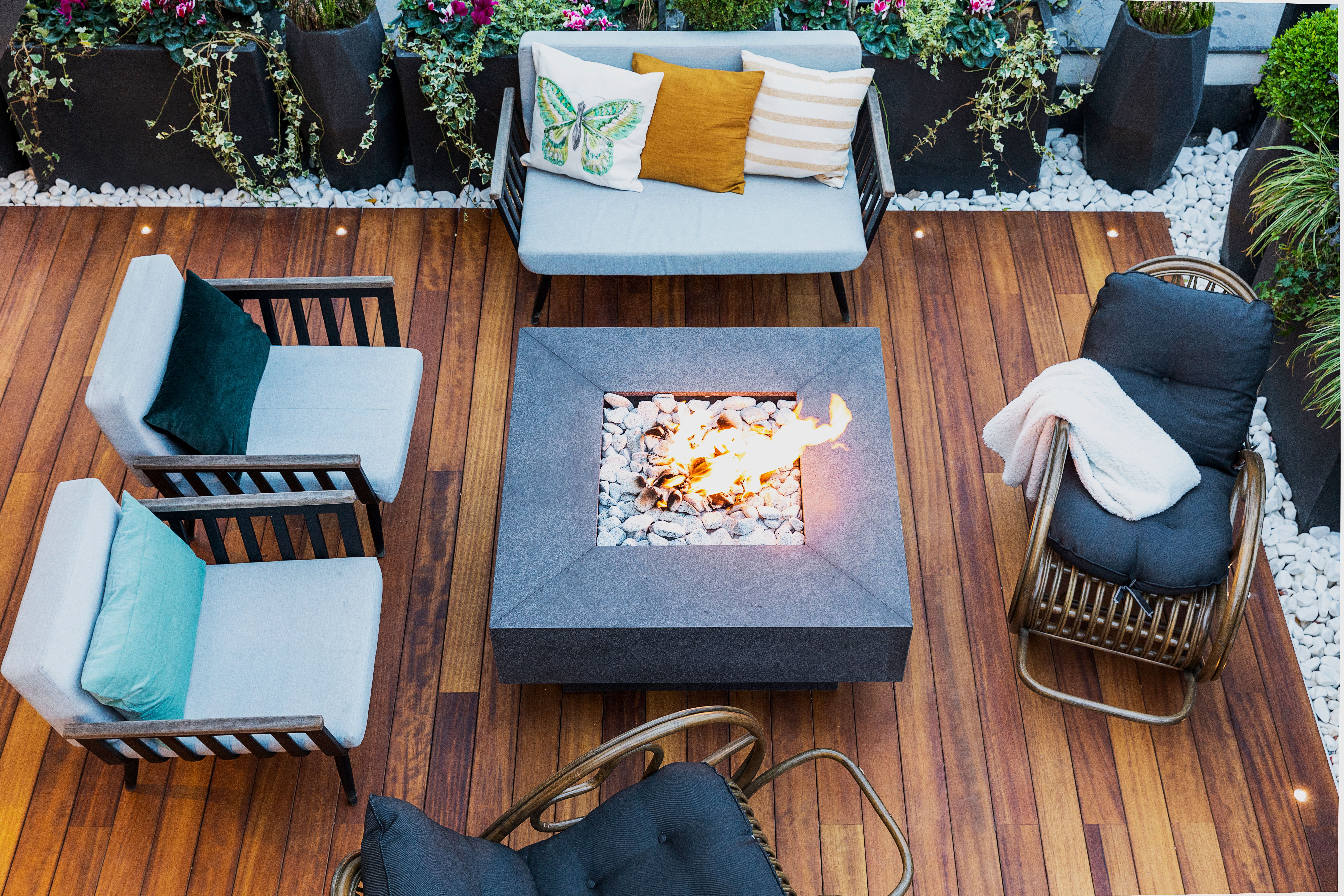 Top-down view of a modern patio with stylish furniture and a central firepit